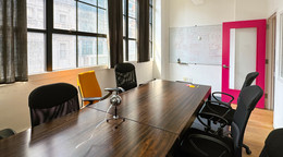 A conference room with a long table and whiteboard